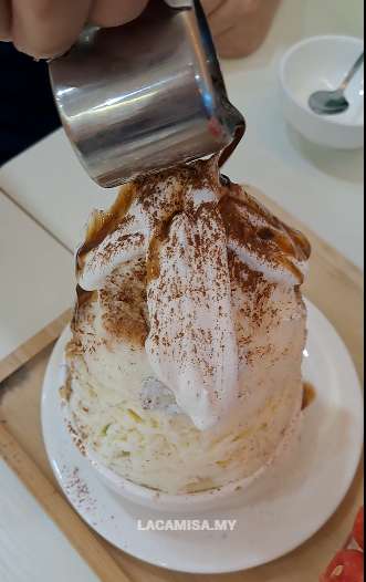 Pouring the cocoa sauce on top of the shaved ice of Chocolate Tiramisu Kakigori in MyKori Dessert Cafe