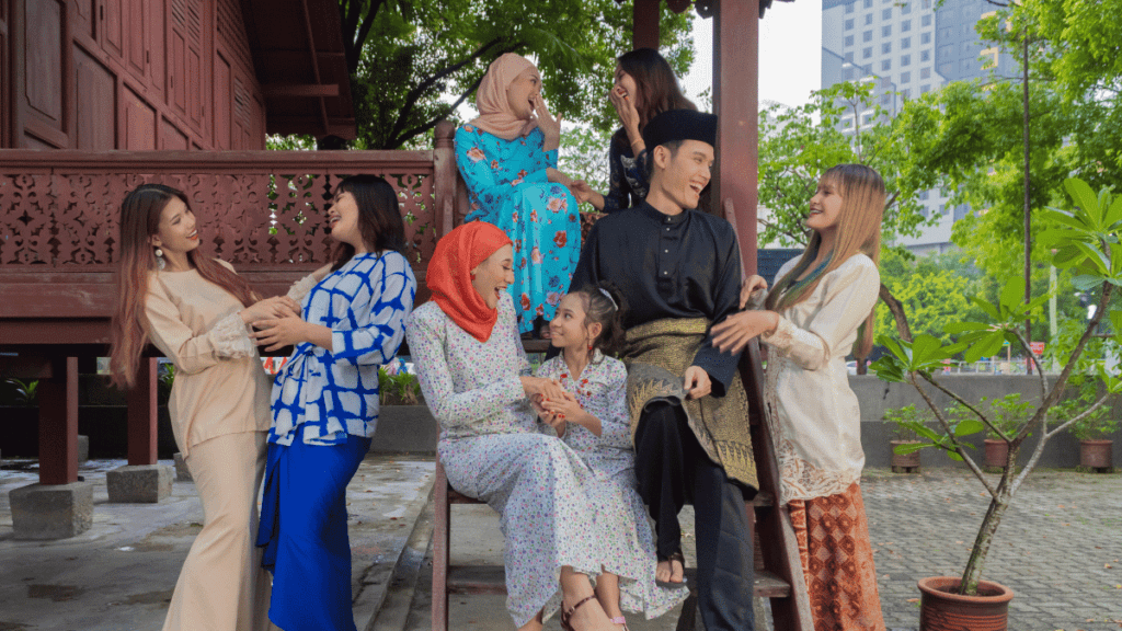 During the Hari Raya celebration, the Malay community embraces Malaysian cultures and traditions by wearing traditional attire such as baju kurung for women and baju melayu for men, symbolizing unity and cultural pride.