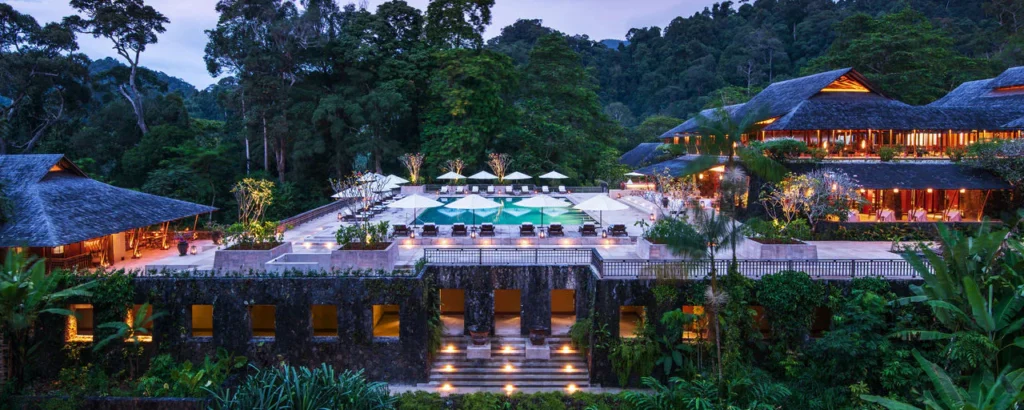 The Datai Langkawi rainforest resort surrounded by lush greenery and a private beach.