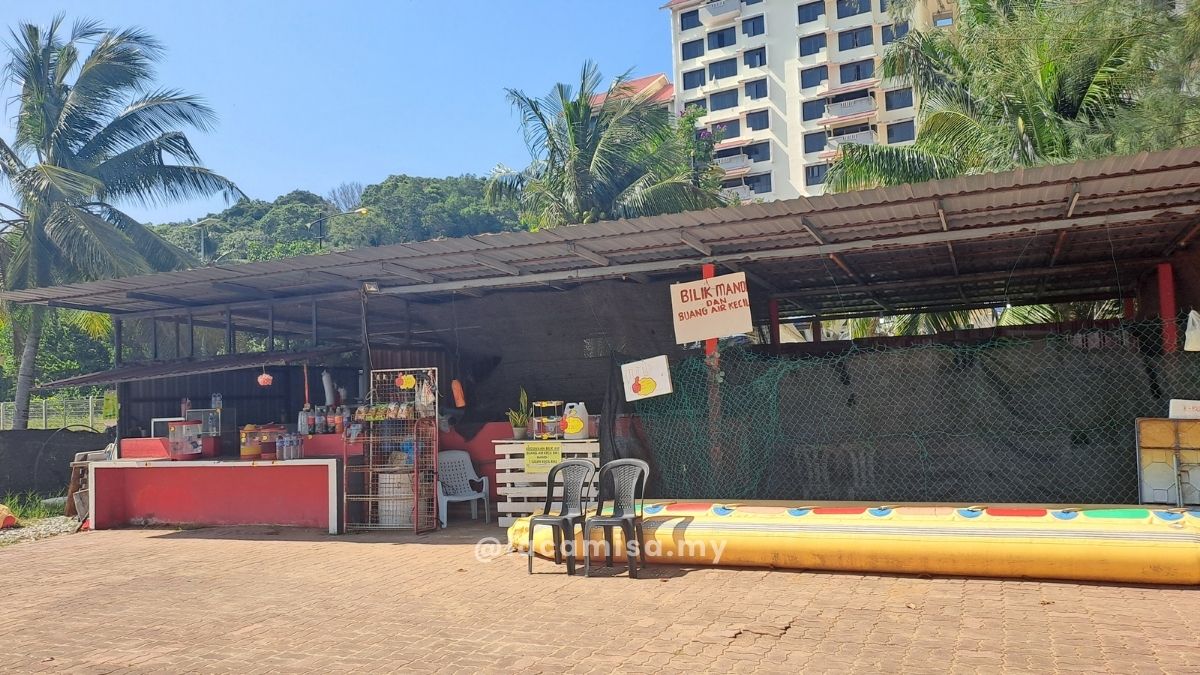A small shop selling drinks, located next to the entrance sign for the toilet and shower facilities.<br>